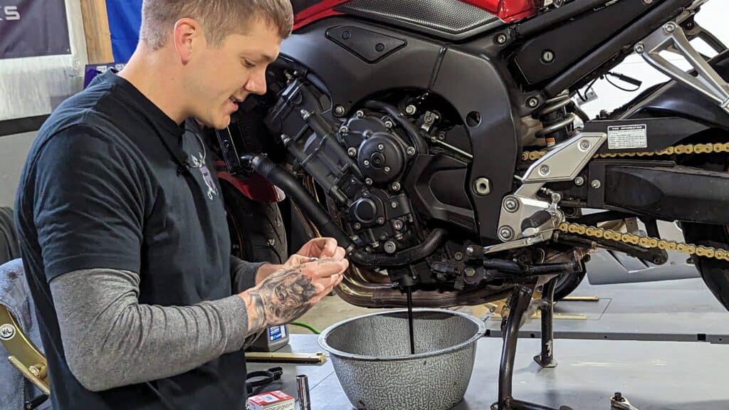 photo of Ryne performing an oil change, one of the many motorcycle repair services he offers