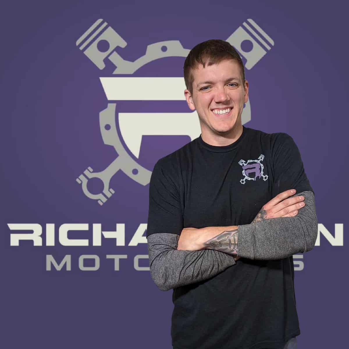 photo of Ryne Richardson in front of a banner for his business Richardson MotoWorks